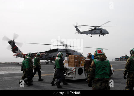 110320-N-KF029-170 OCÉAN PACIFIQUE (20 mars 2011) marins et soldats se préparent à charger la nourriture et des fournitures de secours d urgence sur un SH-60F Sea Hawk attribué aux chefs d'Escadron d'hélicoptères anti-sous-marin (HSL) 51 à bord du porte-avions USS Ronald Reagan (CVN 76). Ronald Reagan est au large du Japon de fournir des secours en cas de catastrophe et d'aide humanitaire, comme indiqué dans le cadre de l'opération Tomodachi. (U.S. Photo par marine Spécialiste de la communication de masse de la classe 3ème Anthony Johnson/libérés) US Navy 110320-N-KF029-170 marins et soldats se préparent à l'alimentation et de charge Banque D'Images