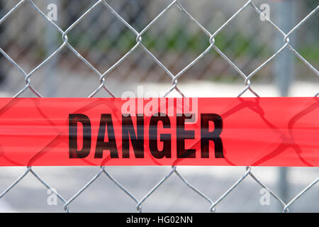 Danger ruban réfléchissant rouge à travers une clôture pour empêcher les piétons hors de la zone de construction, Close up sur le mot danger Banque D'Images