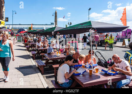 Front de l'Anglais à Ramsgate avec des gens assis à des tables et des chaises à l'ombre des parasols, profitant des boissons et de la nourriture par temps chaud en été. Banque D'Images