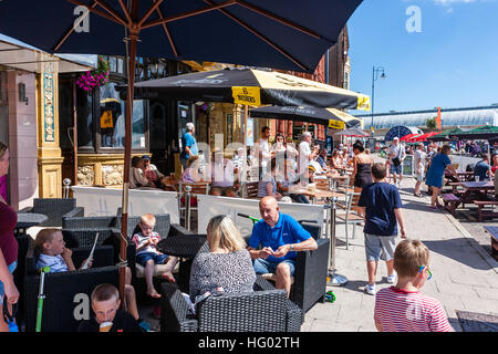 Front de l'Anglais à Ramsgate avec des gens assis à des tables et des chaises à l'ombre des parasols, profitant des boissons et de la nourriture par temps chaud en été. Banque D'Images