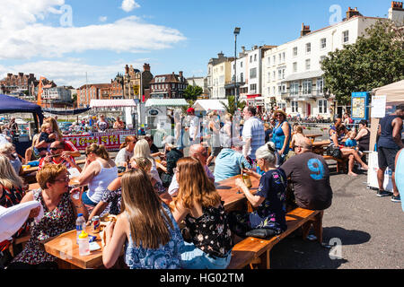 Front de l'Anglais à Ramsgate avec des gens assis à des tables et des chaises de prendre un verre au cours de temps très chaud en été. Banque D'Images