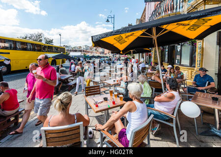 Front de l'Anglais à Ramsgate avec des gens assis à des tables et des chaises à l'ombre des parasols, prendre un verre au cours de temps très chaud en été. Banque D'Images