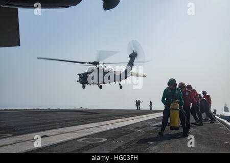 160721-N-QI061-434 DÉTROIT D'ORMUZ (21 juillet 2016) - Les marins s'arc-boutent comme un MH-60S Sea Hawk affecté à l'hélicoptère de chiens poussiéreux de l'Escadron de Combat de mer (HSC) 7 atterrit sur le pont d'envol du porte-avions USS Dwight D. Eisenhower (CVN 69) (Ike). Ike et son Groupe aéronaval sont déployés à l'appui de l'opération inhérents à résoudre, les opérations de sécurité maritime et les efforts de coopération en matière de sécurité dans le théâtre dans la 5e flotte américaine zone d'opérations. (U.S. Photo par marine Spécialiste de la communication de masse, troisième classe Nathan Beard/relâché), USS Dwight D. Eisenhower 16072 Déploiement Banque D'Images