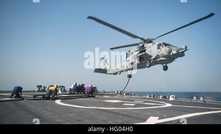 Les marins à bord du destroyer à missiles guidés USS Stout (DDG 55) effectuent le ravitaillement en vol avec un hélicoptère MH-60R Sea Hawk affecté au Helicopter maritime Strike Squadron 74 alors qu'il est déployé avec le Eisenhower Carrier Strike Group à l'appui des opérations de sécurité maritime dans la zone de responsabilité de la 5e flotte américaine. Banque D'Images