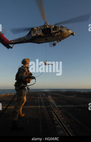 111006-N-DU438-1056 de la mer d'Oman (oct. 6, 2011) marins affectés à l'unité mobile de destruction des engins explosifs (EODMU 2) rappel d'un MH-60S Sea Hawk affectés à l'Escadron d'hélicoptères de combat de la mer (HSC) 9 lors d'un exercice d'entraînement à bord du croiseur lance-missiles USS Gettysburg (CG 64). HSC-9 et Gettysburg sont déployés dans le domaine de la 5e Flotte des États-Unis mène la responsabilité des opérations de sécurité maritime et missions d'appui dans le cadre des opérations Enduring Freedom et New Dawn. (U.S. Photo par marine Spécialiste de la communication de masse 3 Classe Betsy Knapper/libérés) US Navy 111006-N-DU A438-056 Banque D'Images