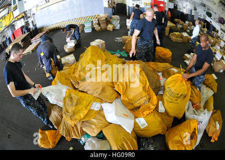 Les marins à bord du navire d'assaut amphibie USS Essex (LHD 2) trient le courrier reçu du pétrolier de réapprovisionnement de la flotte du Military Sealift Command USNS Tippecanoe (T-AO 199) à la suite d'un réapprovisionnement en cours alors qu'il était déployé dans le Pacifique occidental. Banque D'Images