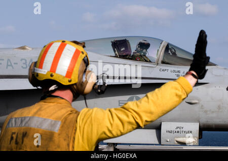 120216-N-JN664-090 de la mer d'Oman (fév. 16, 2012) Un marin dirige le pilote d'un F/A-18C Hornet affectés à la grève de Blasters bleu escadron de chasse (VFA) 34 dans le poste de pilotage de la classe Nimitz porte-avions USS ABRAHAM LINCOLN (CVN 72). Abraham Lincoln est déployé sur le 5e Flotte des États-Unis zone de responsabilité des opérations de sécurité maritime, les efforts de coopération en matière de sécurité dans le théâtre et missions d'appui dans le cadre de l'opération Enduring Freedom. (U.S. Photo par marine Spécialiste de la communication de masse Seaman Apprentice Karolina A. Martinez/libérés) US Navy 120216-N-JN664-090 dirige un marin Banque D'Images