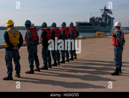 Les marins affectés au quai de débarquement amphibie USS Carter Hall (LSD 50) se préparer à présenter des amarres de quai de débarquement amphibie USS Fort McHenry (LSD 43) après c'est retour à l'accueil port. (U.S. Photo par marine Spécialiste de la communication de masse 2e classe Scott Pittman/relâché), USS Fort McHenry, homecoming 121130-N-FI736-016 Banque D'Images