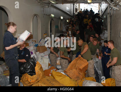Les marins et les Marines trient le courrier pendant le réapprovisionnement en cours à bord de l'USS Green Bay (LPD 20). Le navire opère avec le Peleliu Amphibious Ready Group et embarque la 15e Marine Expeditionary Unit pour soutenir la sécurité maritime dans la zone de responsabilité de la 5e flotte américaine. Banque D'Images