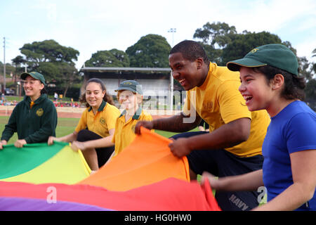 Technicien de systèmes d'information de la Marine américaine 2e classe Jeremy Franklin, deuxième à partir de la droite, affecté à la commande amphibie USS Blue Ridge (CAC 19), joue un jeu avec des enfants australiens lors d'un événement de service communautaire avec Lugarno Public School à Sydney, Australie, le 18 juillet 2013. (U.S. Photo par marine Spécialiste de la communication de masse 3 Classe Jared Harral/relâché), USS Blue Ridge operations 130718-N-NN332-161 Banque D'Images