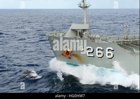 Dauphins nagent en face de la Marine royale australienne HMAS citernes commerciaux Sirius (O 266) au cours d'un ravitaillement en mer avec la marine américaine de classe Ticonderoga croiseur lance-missiles USS ANTIETAM (CG 54) au cours de Sabre 2013 Talisman. Talisman Saber est une bi-activité de formation visant à améliorer la préparation au combat et l'interopérabilité des forces australiennes et américaines. (U.S. Photo par marine Spécialiste de la communication de masse 3 Classe Declan Barnes/libérés), les navires australiens nous réapprovisionner en mer 130719-N-TG831-100 Banque D'Images