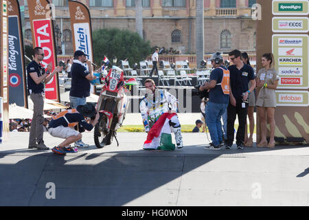 Asunción, Paraguay. 1er janvier 2017. Laller Racing, le cavalier Lajos Horvath s'agenouille d'un drapeau sur le podium lors de la cérémonie symbolique de départ du Rallye de Dakar 2017 à Asunción, au Paraguay. Credit: Andre M. Chang/Alamy Live News Banque D'Images