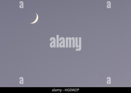 Croissant de lune et Vénus sont visibles dans le ciel après le coucher du soleil Banque D'Images