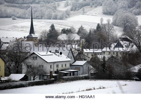 Un village clocher d'église et les toits couverts de neige en Bavière, Allemagne, un jour d'hiver. Banque D'Images