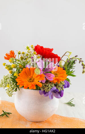 Des fleurs décoratives dans un vase blanc Banque D'Images