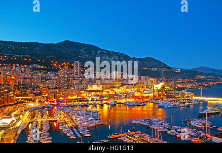 Panorama du Port Hercule avec les yachts et bateaux, entouré par des milliers de lumières de la ville, qui se reflète dans l'eau, de Monaco. Banque D'Images