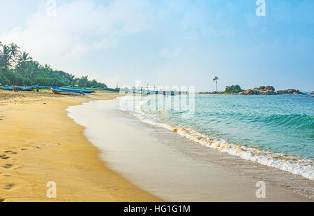 La promenade le long de la belle plage de sable avec les bateaux de pêche, voile tout au long de la journée, Hikkaduwa, au Sri Lanka. Banque D'Images