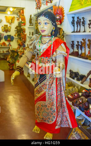 La femme en sari traditionnel de marionnettes colorées dans le masque store Banque D'Images