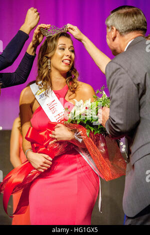 Tenant un bouquet, une reine de beauté habillé formellement reçoit sa couronne par le maire de Huntington Beach, CA. Remarque la ruban. Banque D'Images