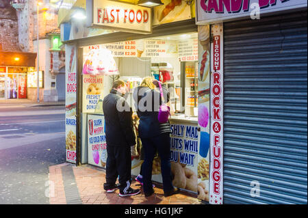 Les commandes de la famille restauration rapide à partir d'une prise sur la promenade de Blackpool, Lancashire, Royaume-Uni. Banque D'Images