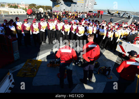 Expliquer les marins et les procédures de récupération de crash à l'Arizona State University Marching Band dans le cadre d'une tournée dans le porte-avions USS Ronald Reagan (CVN 76). Le navire a accueilli les joueurs de Sun Devils de Arizona State University et la Red Raiders de Texas Tech University pour la Marine et le Marine Corps Maison de vacances Bol Déjeuner. Les équipes jouent dans le 36e Congrès annuel de l'Université National Bowl le 30 décembre au Stade Qualcomm de San Diego. (U.S. Photo par marine Spécialiste de la communication de masse 2e classe Timothy M. Black/relâché). USS Ronald Reagan tour 131229-N-AV746-117 Banque D'Images