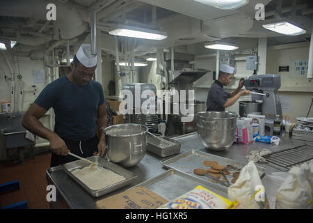 Spécialiste culinaire de 3e classe Brandon Penn aux îles Vierges, à gauche, et Spécialiste culinaire Seaman Lyndon Paalisbo à partir de San Jose, Californie, préparer le dîner pour marins et Marines dans l'office de transport amphibie USS Denver dock (9 LPD). Denver est attribué à l'Bonhomme Richard Groupe amphibie et est en train de mener des opérations dans la 7e flotte américaine Zone d'opérations. (U.S. Photo par marine Spécialiste de la communication de masse 3 classe Bradley J. Gee/relâché), USS Denver activité cuisine 140302-N-IC565-029 Banque D'Images