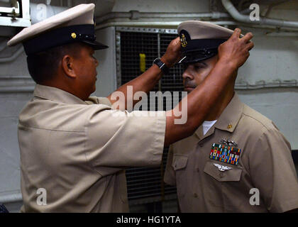 Master Chief Spécialiste Personnel Jésus Catubay met un couvercle sur le spécialiste des questions de personnel John Valentin lors d'une cérémonie à bord de l'épinglage de transport amphibie USS dock Green Bay (LPD 20). Le navire effectue une période de cour BAE Systems à San Diego la réparation des navires. (U.S. Photo par marine Spécialiste de la communication de masse 1re classe Elizabeth Merriam/relâché), USS Green Bay Chef Pinning 140606-N-BB534-030 Banque D'Images