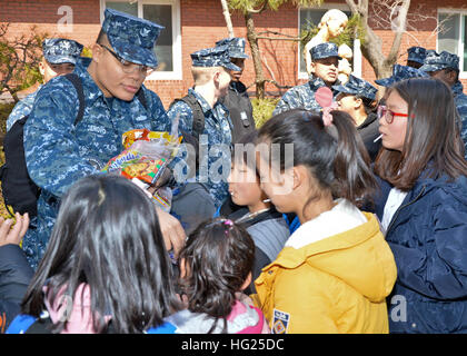 JINHAE, République de Corée (14 mars 2015) - Gunner's Mate 2e classe Chance Denovo, un marin affecté à l'appel d'offres sous-marin USS Frank Câble (comme 40), distribue des collations aux enfants de l'espoir Accueil orphelinat à Jinhae Jinhae, République de Corée, le 14 mars. Frank a fait don de 700 Câble de nourriture pour l'orphelinat. Frank, l'avant déployés dans l'île de Guam, procède à l'entretien et du soutien des sous-marins et navires de surface déployés dans la 7e Flotte des États-Unis et de la zone de responsabilité est en ce moment sur un service en cours de période. (U.S. Photo par marine Spécialiste de la communication de masse 2e classe Greg Banque D'Images