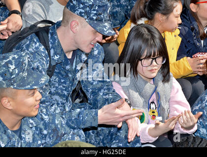 JINHAE, République de Corée (14 mars 2015) - Gunner's Mate 3 classe Ian Dea, un marin affecté à l'appel d'offres sous-marin USS Frank Câble (comme 40), parle à un enfant de l'espoir Accueil orphelinat à Jinhae Jinhae, République de Corée, le 14 mars. Frank a fait don de 700 Câble de nourriture pour l'orphelinat. Frank, l'avant déployés dans l'île de Guam, procède à l'entretien et du soutien des sous-marins et navires de surface déployés dans la 7e Flotte des États-Unis et de la zone de responsabilité est en ce moment sur un service en cours de période. (U.S. Photo par marine Spécialiste de la communication de masse 2e classe Greg House/libérés) Banque D'Images