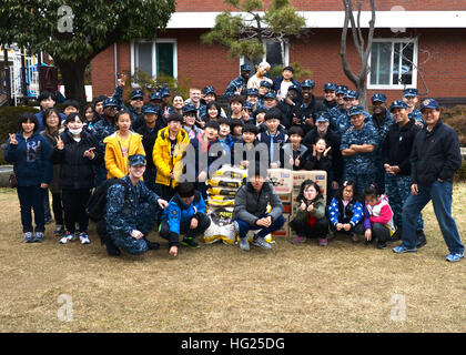 CHIN-HAE, République de Corée (14 mars 2015) - Les marins affectés à l'adjudication du sous-marin USS Frank Câble (comme 40) posent pour une photo de groupe avec les enfants et le personnel de l'Orphelinat Espoir Jinhae Accueil avec un don de nourriture de Frank Câble dans Jinhae, République de Corée (ROK), le 14 mars. Frank a fait don de 700 Câble de nourriture pour l'orphelinat. Frank, l'avant déployés dans l'île de Guam, procède à l'entretien et du soutien des sous-marins et navires de surface déployés dans la 7e Flotte des États-Unis et de la zone de responsabilité est en ce moment sur un service en cours de période. (U.S. Photo par Marine Communications de Masse Banque D'Images