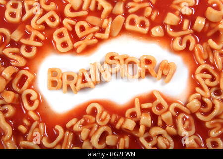 Le mot 'brainstorming' écrit en alphabetti, pâtes spaghetti orange en forme de lettres. Banque D'Images