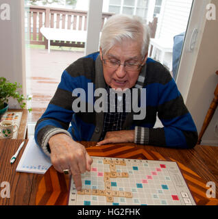 Grey haired man un match intense de scrabble. Downers Grove Illinois IL USA Banque D'Images