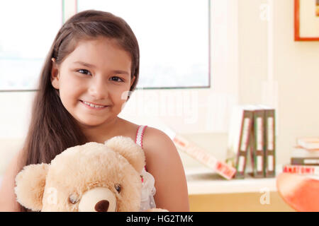 Portrait of smiling girl holding teddy bear Banque D'Images