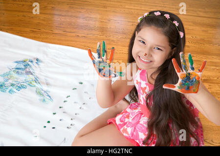 Smiling Girl avec des mains couvertes de peinture Banque D'Images