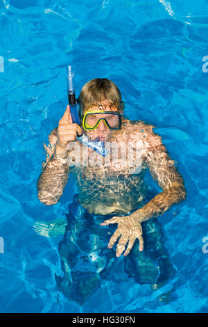 Jeune homme dans la piscine avec tuba Banque D'Images