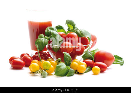 Tomates Raisins rouge et jaune avec du jus de tomate et basilic Banque D'Images