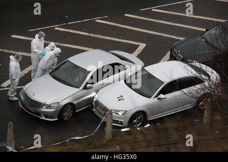 Les policiers de police examinent une voiture à côté d'une Audi argentée (à droite) avec des trous de balle dans son pare-brise, sur la scène près de la jonction J24 de la M62 à Huddersfield, où un homme est mort dans une fusillade de de police lors d'une opération « préprogrammée » vers 18:00 lundi. Banque D'Images