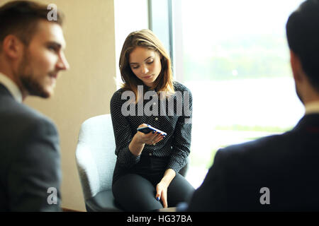 Concept d'équipe, de réflexion. L'équipage d'affaires travaillant avec de nouveaux projet de démarrage en loft moderne. Woman holding smartphone les mains. L'effet horizontal, du film. Banque D'Images