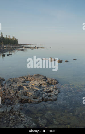 Calme plat après-midi libre de Clear Lake Huron et de l'eau des roches calcaires le long du littoral. Banque D'Images