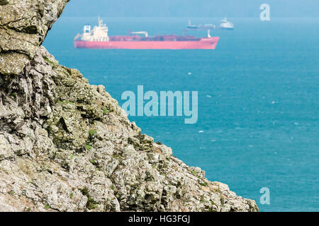 Éperon rocheux sur l'île de Skomer, dans l'arrière-plan est la forme de pétroliers ancrées dans les routes de Saint Brides Bay. Banque D'Images