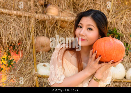 Closeup portrait of happy woman et avoir une grosse orange citrouille dans la main Banque D'Images