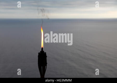 Torch en face de la mer Méditerranée au loin le phare de Sant Sebastià, Llafranc, Girona, Costa Brava, Catalogne, Espagne. Banque D'Images