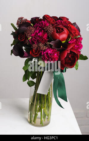 Arrangement floral. Bouquet de pivoines rouge. les fleurs dans un vase en verre. Banque D'Images