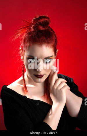 Red haired model with creative makeup in tribal style et couleurs automnales, toile rouge Banque D'Images