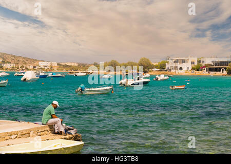 Paros, Grèce 1 août 2016. Homme fixant le filet de pêche à Alyki beach à l'île de Paros en Grèce. Banque D'Images