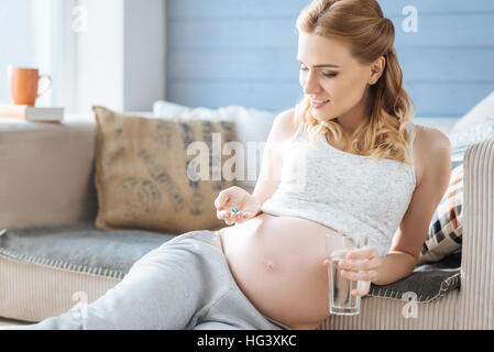 Pregnant woman looking at comprimé dans sa main Banque D'Images