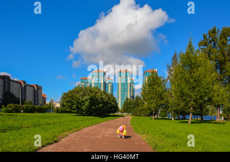 Petite fille en jaune vêtements sur une promenade dans le parc. Banque D'Images