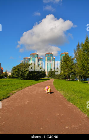 Petite fille en jaune vêtements sur une promenade dans le parc. Banque D'Images