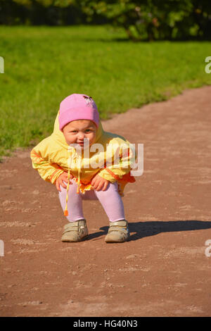 Petite fille en jaune vêtements sur une promenade dans le parc. Banque D'Images