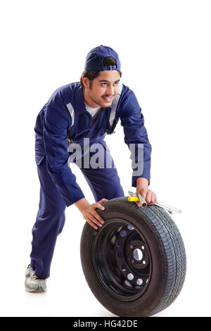 Portrait de mécanicien de voiture avec pneu de rechange et des outils à main Banque D'Images